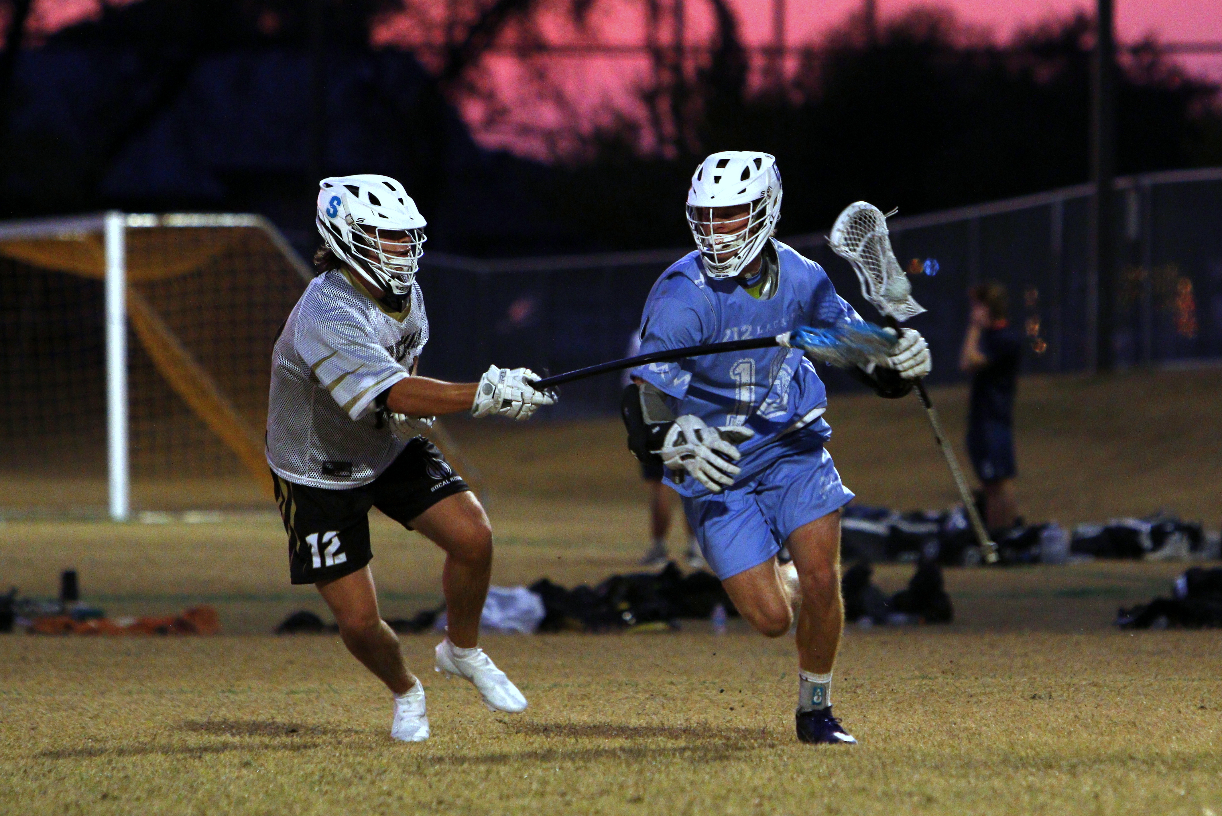 Jon King driving to the goal for 212 Lacrosse at sunset