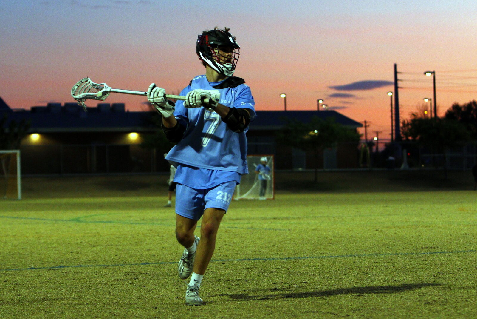 Mason Quick playing for 212 Lacrosse under the lights at sunset