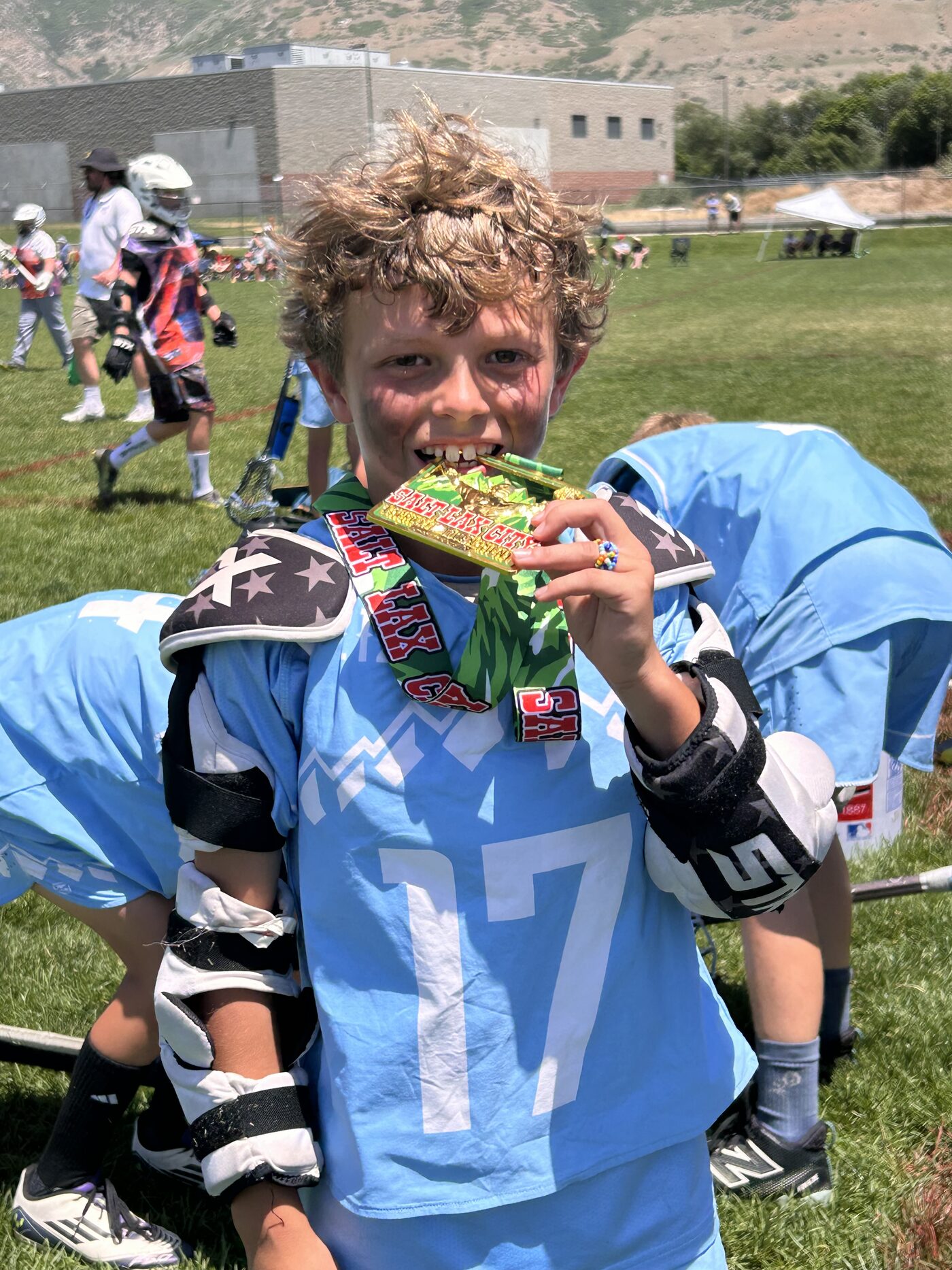 212 Lacrosse player biting his Salt Lax City championship medal